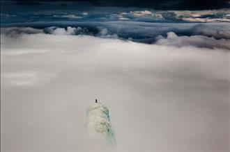 یک کوهنورد روی نوک کوهی در کشور ایسلند ایستاده است